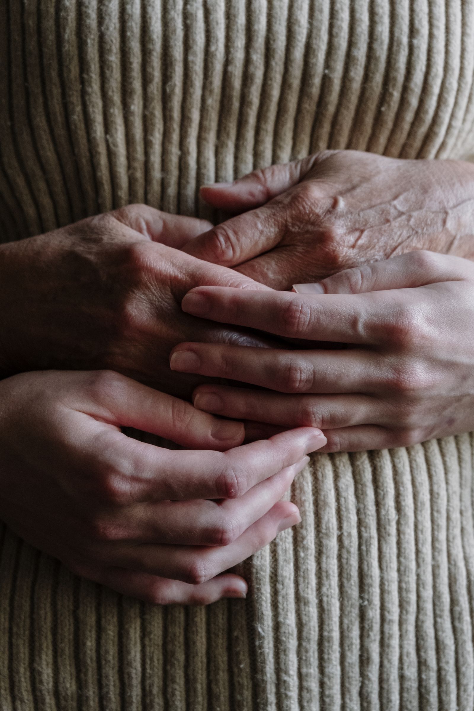 Two people holding hands in quiet reassurance